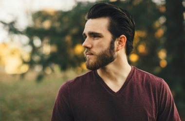 man wearing maroon V-neck t-shirt in forest