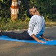 A man sitting on a blue mat in the middle of the road