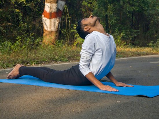 A man sitting on a blue mat in the middle of the road