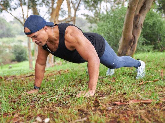 a man is doing push ups in the grass